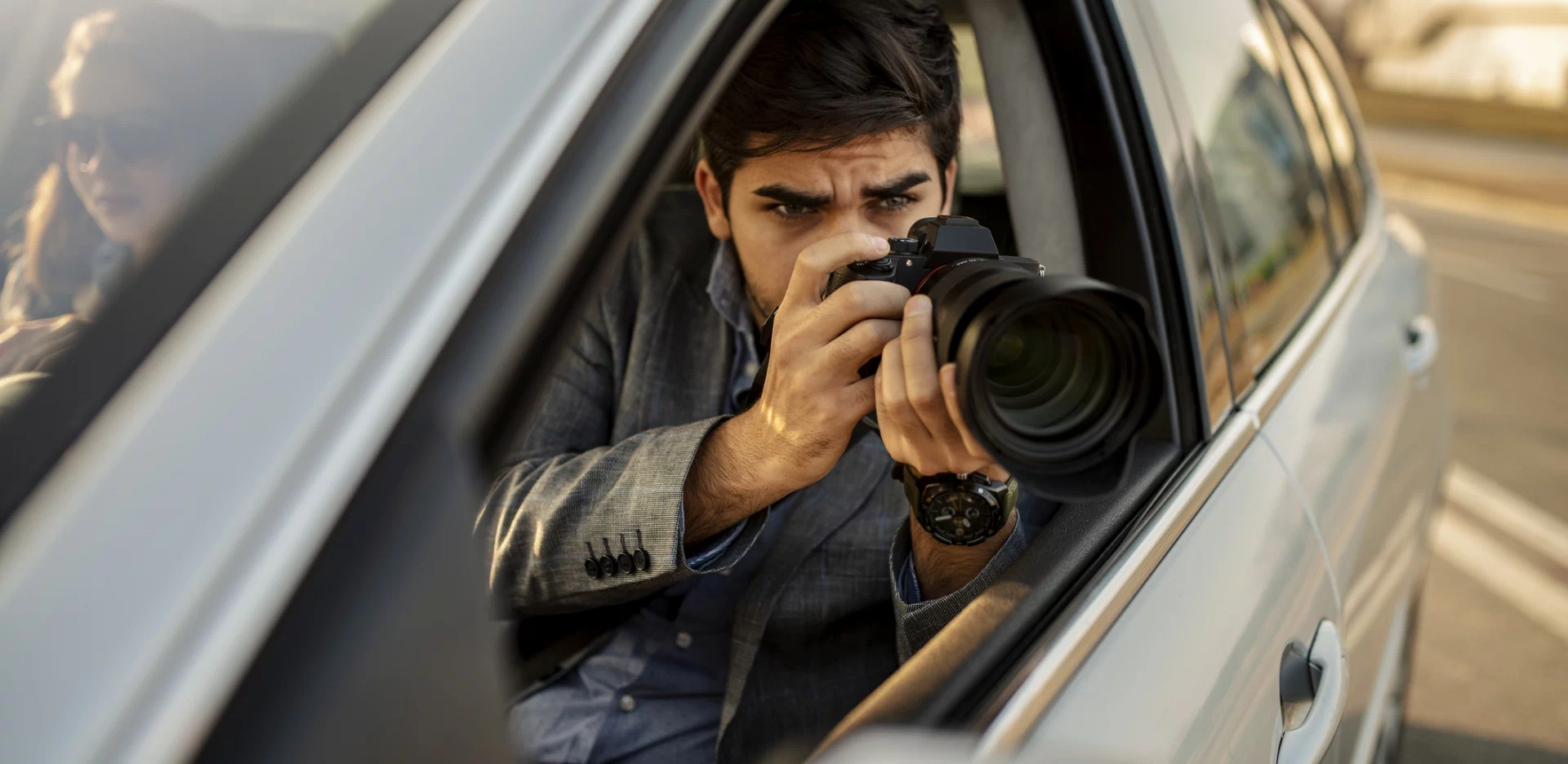 detektyw z aparatem w samochodzie